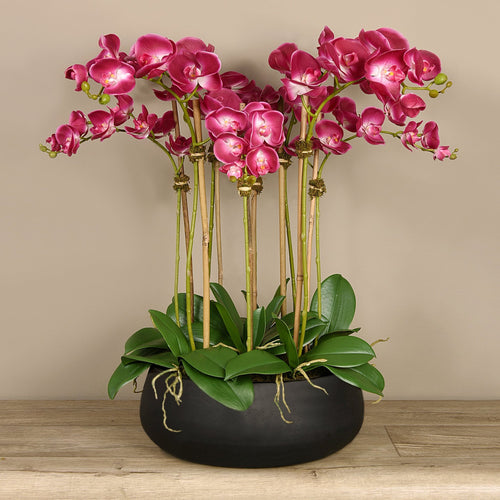 artificial floral arrangement centerpiece with pink orchids in black planter